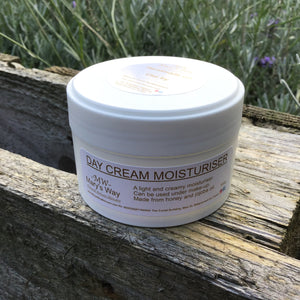 Jar Marys way day cream moisturiser  resting on wooden pallet with foilage in background.